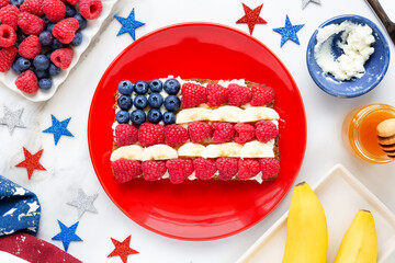 American flag sandwich with fresh fruit like raspberries, banana and blueberries on rye bread with...