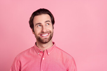 Photo of attractive young happy man look empty space dream news plan isolated on pastel pink color background