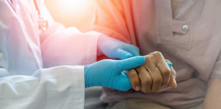 Parkinson And Alzheimer Female Senior Elderly Patient With Caregiver In Hospice Care. Doctor Hand With Stethoscope Check Up Older Woman People. Old Aging Person Seeing Medical Physician In Hospital.