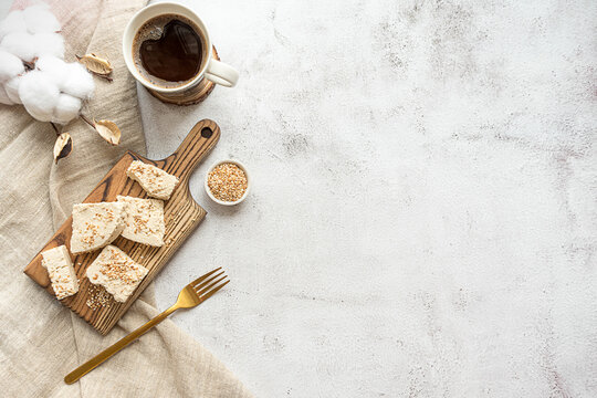 Sliced tahini halva on a wooden board, flat lay