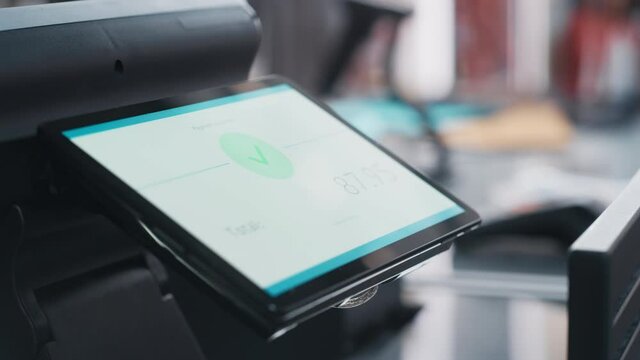 Close Up Footage of a Person Touching an Electronic Fingerprint Recognition Feature on a Digital Screen in Order to Make a Purchase in a Clothing Store. Customer Buying Items in Shop with Digital ID.