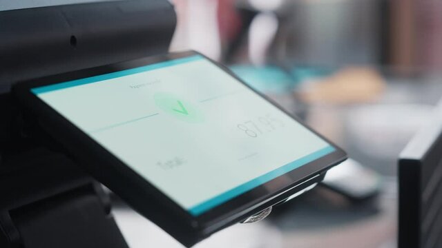 Close Up Footage of a Person Touching an Electronic Fingerprint Recognition Feature on a Digital Screen in Order to Make a Purchase in a Clothing Store. Customer Buying Items in Shop with Digital ID.