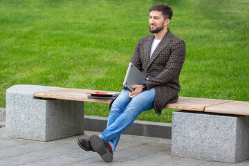 Obraz premium successful businessman resting on a city bench after a completed work project