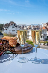 Drinking of brut champagne sparkling wine in flute glasses on outdoor bistro terrace in France