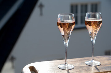 Drinking of rose champagne sparkling wine from flute glasses on outdoor terrace in France