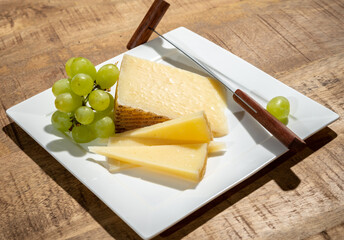 Cheese collection, piece of spanisch hard manchego cheese made in La Mancha region from sheep milk with green grapes