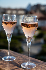 Drinking of rose champagne sparkling wine from flute glasses on outdoor terrace in France