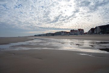 Fototapeta premium Low tide period on yellow sandy beach in small Belgian town De Haan or Le Coq sur mer, luxury vacation destination, summer holidays