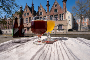Tasting of Belgian beer on open cafe or bistro terrace with view on medieval houses and canals in...