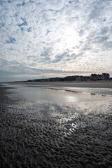 Low tide period on yellow sandy beach in small Belgian town De Haan or Le Coq sur mer, luxury vacation destination, summer holidays