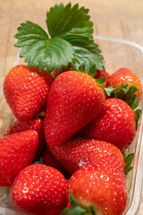 New harvest, plastic box of ripe red sweet strawberry ready to eat
