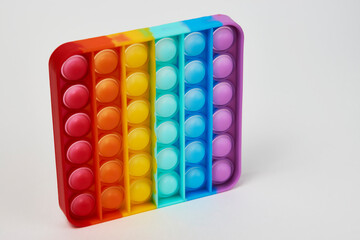 Multicolor poppit toy on a white background, close-up