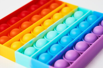 Multicolor poppit toy on a white background, close-up