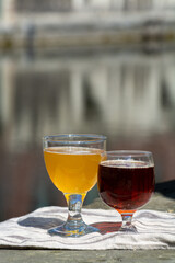 Tasting of Belgian beer on open cafe or bistro terrace with view on medieval houses and canals in Bruges, Belgium