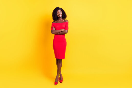 Full length photo of cute adorable dark skin woman wear red clothes arms crossed looking empty space isolated yellow color background