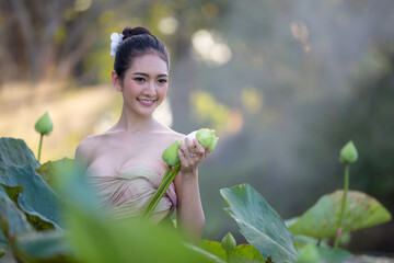 Asian woman harvest lotus flower in the garden,