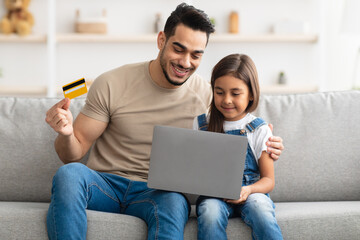 Family using computer and credit card at home