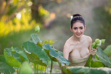 Asian woman harvest lotus flower in the garden, - obrazy, fototapety, plakaty