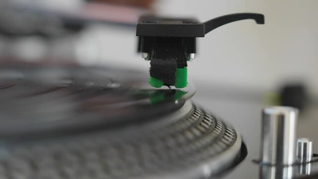 The headshell of the turntable going down to the platter 