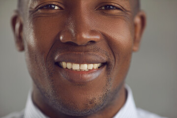 Extreme closeup portrait of happy cheerful handsome young black man with stubble on shaved face...