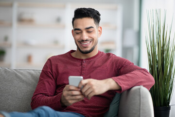 Happy arab man enjoying new mobile application