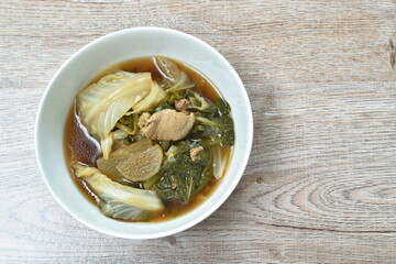 boiled mixed vegetable with chicken in black soybean soup in bowl on table