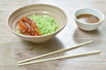 Chinese jade noodles topping slice roasted duck dressing sweet soy sauce picking by chopsticks on bowl