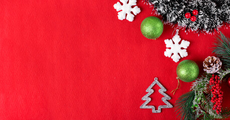 Christmas background on vibrant red with ornaments and wreath. Festive New Year flat lay. Greeting card template