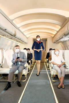 Air Hostess And Passengers In Aircarft Cabin With Face Mask For Protection Of Covid19 In Travel Flight