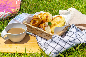 芝生の上のカフェオレとパン