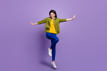 Fototapeta na wymiar Full size photo of young excited girl happy positive smile hands wings jump isolated over violet color background