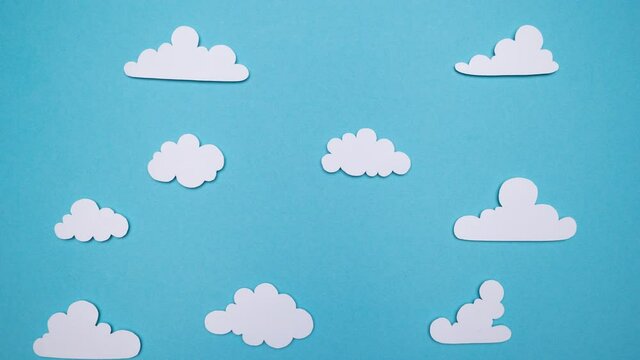 Stop Motion Animation. Paper cut out balloons floating through a blue sky and fluffy white clouds
