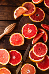 sliced pieces of grapefruit lie on the table on the dark wooden countertop