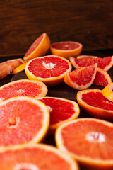 sliced pieces of grapefruit lie on the table on the dark wooden countertop