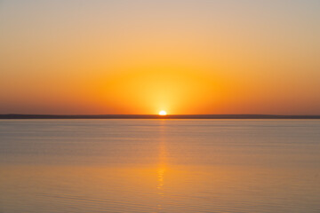 Horizontal line of calm sea at sunset