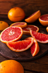 sliced pieces of grapefruit lie on the table on the dark wooden countertop