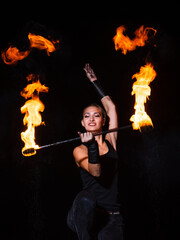 Fire and sparks. Sexy woman twirl burning stick in darkness. Fire performance. Baton twirling.