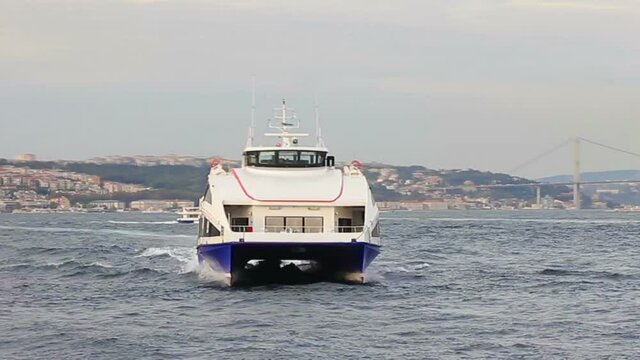 Istanbul city fast catamaran underway into open sea. Close tracking shot.  Bosporus straits with a domestic sea bus.
