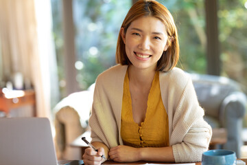 Portrait of smiling asian woman working from home