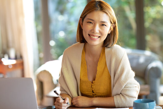 Portrait of smiling asian woman working from home