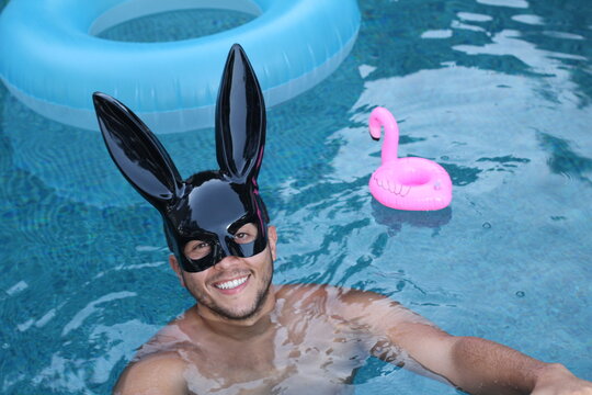 Fantastic man wearing bunny mask in swimming pool