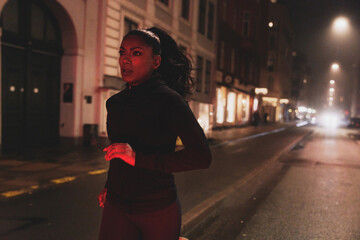 Woman running at night on a city street