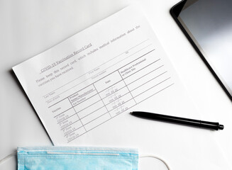 Obraz premium COVID-19 Vaccination Record Card with a medical mask, the need for vaccination to go abroad