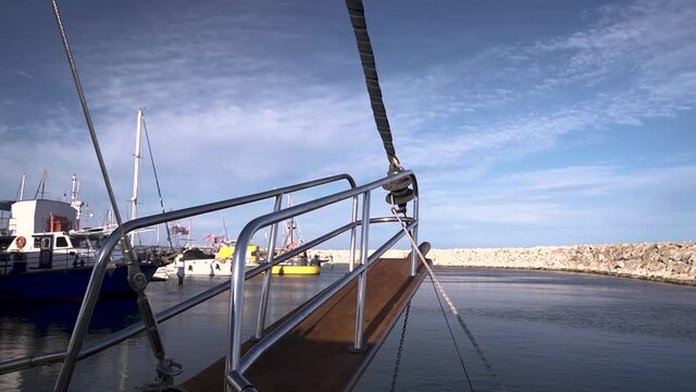 Traditional sloop boat sailing out the pot towards the open ocean.