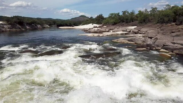 Low flying drone shot over fast flowing rapids on a tropical river in South America