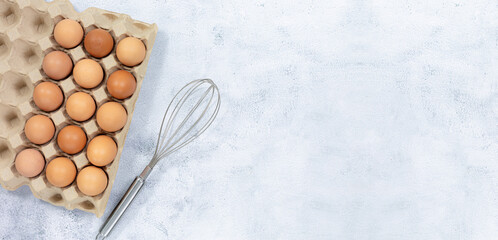 Eggs and egg whisks,Top View three eggs in glasses bowl, blurred eggs in wicker basket and egg beater on the floor, preparing preparing for cooking food or dessert, copy space