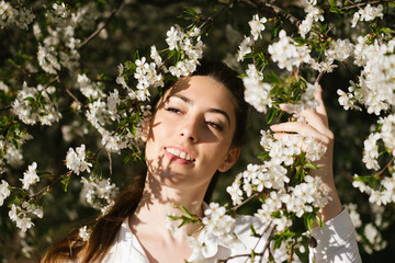 Spring time, Natural beauty. Candid portrait of young women in cherry blooming garden. Pretty woman in spring blossom garden, cherry trees in bloom