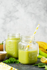 Detox smoothie glass jars. Green healthy drink with spinach,banana, cucumbers, lime and mint.