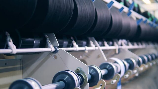 Close up of threads getting reeled between spools