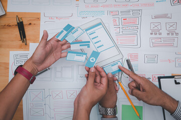 UX or UI designers designing on their smartphone application layout prototype project.